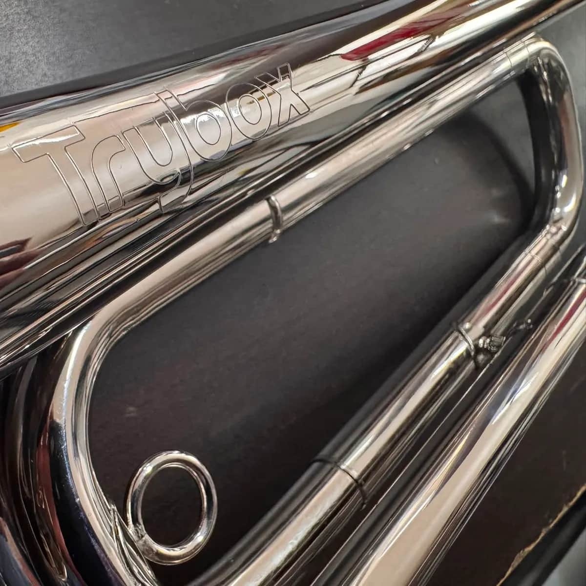 Close-up of a chrome bugle engraved with the Trybox name